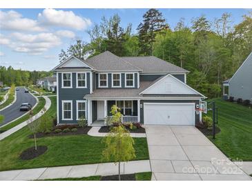 Charming two-story home with a well-manicured lawn, attached garage, and inviting front porch at 8903 Ansley Park Pl, Huntersville, NC 28078