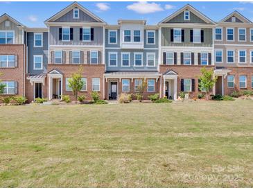Charming townhomes featuring colorful exteriors, brick accents, and well-maintained landscaping offer curb appeal at 138 Marron Dr # 25, Indian Trail, NC 28079