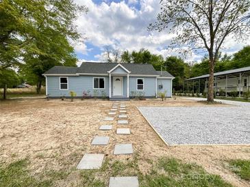 Charming single-story home with light blue siding and a walkway of stepping stones to the front door at 171 Three Cs Rd, Kershaw, SC 29067