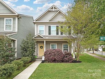 Charming two-story home with a well-manicured lawn and inviting yellow door at 20025 Metaphor Mews None, Davidson, NC 28036