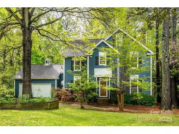Charming blue two-story home with lush landscaping and a side-entry garage, offering curb appeal at 3005 Kenninghall Ct, Charlotte, NC 28269