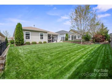 Well-maintained backyard with lush green grass, landscaping, and a patio area perfect for outdoor entertaining at 4831 Looking Glass Trl, Denver, NC 28037