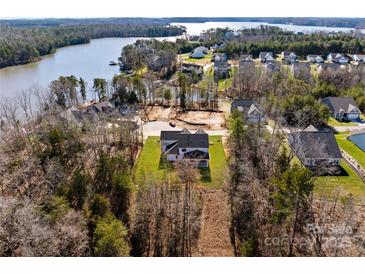 A home with a big lawn and a covered porch in a rural area near a lake at 13453 Portside Ln, Lancaster, SC 29720