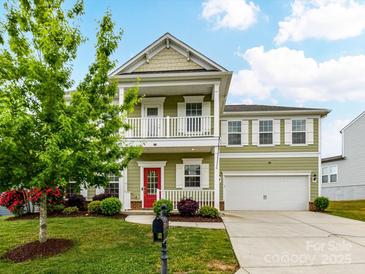 Charming two-story home with a double porch, a vibrant red door, and a well-manicured front yard at 15747 Reynolds Dr, Indian Land, SC 29707