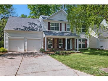 Charming two-story home with a well-manicured lawn, a two-car garage, and red window shutters at 2856 Huckleberry Hill Dr, Fort Mill, SC 29715