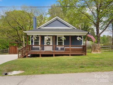 Charming blue home featuring a cozy front porch and beautifully landscaped front yard at 402 Sidney Johnson St, Fort Mill, SC 29715