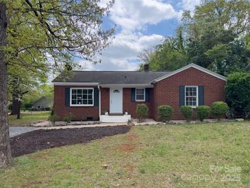 Charming brick home featuring a well-manicured front yard with mature trees and tasteful landscaping at 430 Coolidge Ave, Statesville, NC 28677