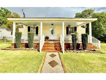 Charming home featuring a cozy front porch with rocking chairs and beautiful landscaping at 45 Oak St, Great Falls, SC 29055