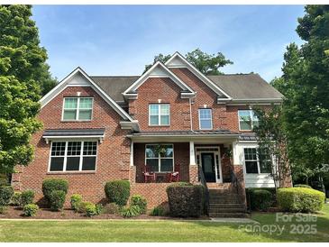 Beautiful brick home with meticulously maintained lawn and front porch seating at 4711 Pearmain Dr, Waxhaw, NC 28173