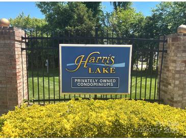 Harris Lake Privately Owned Condominiums community entrance sign with black metal fence, brick columns, and manicured lawn at 5810 Harris Grove Ln, Charlotte, NC 28212