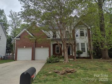 Charming two-story home with a brick facade and well-manicured lawn offers great curb appeal at 7731 Harrington Woods Rd # 17, Charlotte, NC 28269