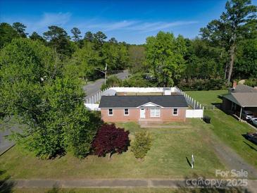 Aerial view of a brick home with a fenced yard, surrounded by lush greenery at 1005 Clarkson St, Rock Hill, SC 29730