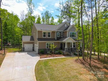 Charming two-story home featuring a two-car garage, inviting front porch and a basketball court at 11215 Dappled Light Trl, Charlotte, NC 28227
