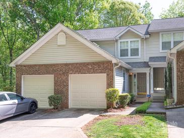 Charming townhome with a two-car garage, brick accents, and a well-maintained front yard at 1203 Maple Shade Ln, Charlotte, NC 28270
