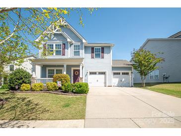 Charming two-story home with a well-manicured lawn and a two-car garage on a sunny day at 2207 Atwell Glen Ln, Pineville, NC 28134