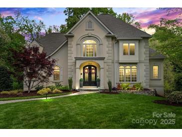 Stunning two-story home featuring manicured lawn and stone facade, complemented by lush landscaping at 2500 Giverny Dr, Charlotte, NC 28226