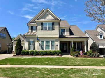 Charming two-story home with a well-manicured lawn and professionally landscaped yard on a sunny day at 313 Newington Ct, Fort Mill, SC 29715