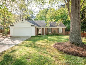 Charming brick home with a lush front yard and attached two-car garage, perfect for suburban living at 8718 Rittenhouse Cir, Charlotte, NC 28270