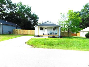 Charming single-story home with a welcoming front porch, freshly cut grass, and a new wooden fence at 109 W Poplar St, Stanley, NC 28164