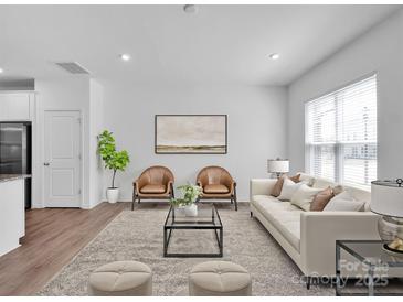 Bright living room featuring hardwood floors, natural light, and contemporary furnishings at 1834 Teachers House Nw Rd, Concord, NC 28027