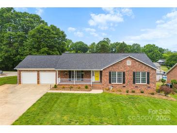 Charming brick ranch home features a two-car garage, inviting front porch, and well-manicured lawn at 2459 Glenridge Dr, Gastonia, NC 28054