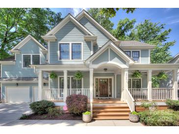 Charming two-story home boasts a welcoming front porch, complemented by mature trees and manicured landscaping at 2729 Clemson Ave, Charlotte, NC 28205