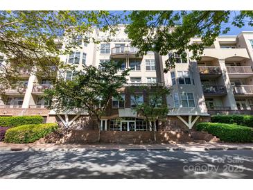 Attractive multi-story building with brick facade and balconies surrounded by lush trees and landscaping at 405 W 7Th St # 408, Charlotte, NC 28202