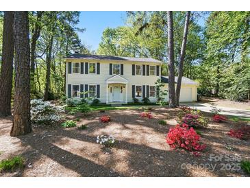 Charming two-story home featuring a white exterior, black shutters, and a beautifully landscaped front yard at 505 Southland Rd, Huntersville, NC 28078