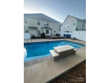Inviting backyard pool with stone feature, patio, and fenced yard at 5228 Sunriver Rd, Gastonia, NC 28054