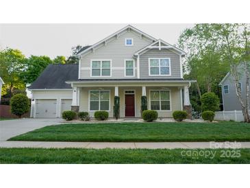Charming two-story home with a well-manicured lawn and inviting front porch at 5808 Mcdowell Run Dr, Huntersville, NC 28078
