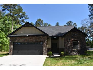 Charming single-story home featuring stone accents, a dark gray roof, and a two-car garage at 6519 Pargo Rd, Charlotte, NC 28216