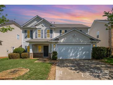 Charming two-story home with a well-manicured lawn and attached two-car garage with neutral siding at 6618 Latherton Ln, Charlotte, NC 28278