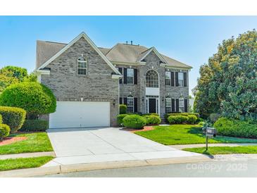 Charming gray brick two-story home with a well-manicured lawn, mature trees, and a two car garage at 709 Circle Trace Rd, Monroe, NC 28110