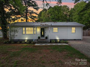 Charming single-story home featuring a metal roof, white siding, and well-manicured front lawn at 8475 Nc 49 N Hwy, Mount Pleasant, NC 28124