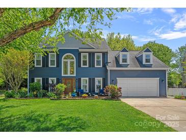 Charming two-story home with a well-manicured lawn, a two car garage, and inviting front porch at 8651 Walsham Dr, Charlotte, NC 28277