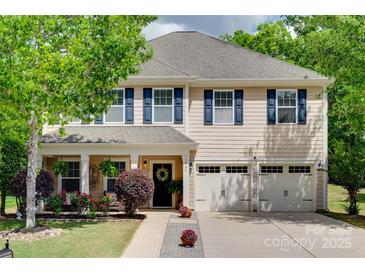 Charming two-story home featuring a manicured lawn and three-car garage at 985 Angelica Ln, Tega Cay, SC 29708