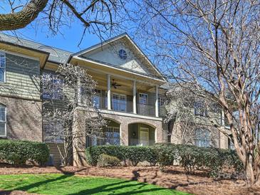 Stunning condo exterior showcasing a covered porch, brick accents, and lush landscaping at 1123 Park West Dr, Charlotte, NC 28209