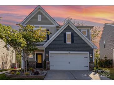 Charming two-story home with stone accents, a well-manicured lawn, and a two car garage at 1313 Loggerhead Dr, Lancaster, SC 29720