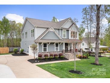 Stunning two-story home with gray siding, stone accents, manicured lawn, and a paved driveway at 137 Brawley Woods Ln, Mooresville, NC 28115