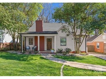 Charming home with manicured lawn, brick chimney, and covered front porch, perfect for relaxing at 1751 Merriman Ave, Charlotte, NC 28203