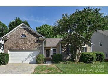 Charming brick home with a well-manicured lawn and attached two-car garage at 2415 Tory Oak Pl, Matthews, NC 28105
