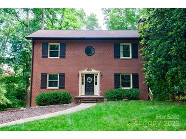Charming two-story brick home with black shutters and lush green landscaping at 2540 Heritage Cir, Statesville, NC 28625