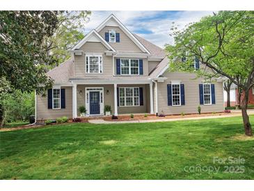 Inviting two-story home boasts a lush lawn, mature trees, and beautiful landscaping at 312 Peach St, Shelby, NC 28150