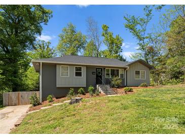 Charming single-story home with gray painted brick and siding, black front door, landscaped yard, and inviting curb appeal at 3423 Sudbury Rd, Charlotte, NC 28205