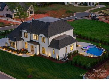 Expansive property showcasing a well-manicured lawn and a luxurious pool area with a spa and patio at 405 Sugar Maple Ln # 41, Weddington, NC 28104