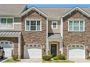 Charming townhome featuring a stone facade, attached garage, and inviting entryway at 4648 Craigmoss Ln, Charlotte, NC 28278