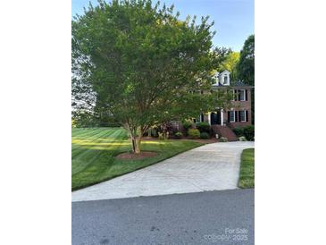 Charming two-story brick home with a well-manicured lawn and mature trees at 503 Bridgestone Ct, Gastonia, NC 28056