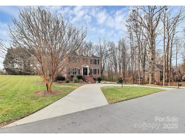 Charming two-story brick home featuring a well-manicured lawn and a long driveway leading to the entrance at 503 Bridgestone Ct, Gastonia, NC 28056
