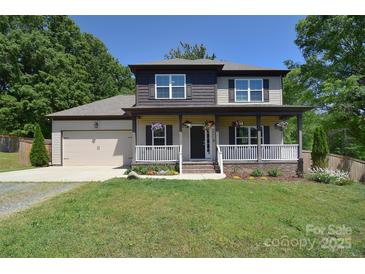 Charming two-story home featuring a welcoming front porch, landscaped yard, and attached two-car garage at 1021 Vickie Ln, Matthews, NC 28104