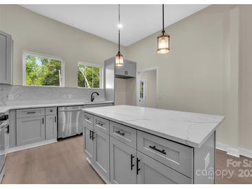 Modern kitchen features an island with a marble countertop and stainless steel appliances at 126 Hemphill Ave, Chester, SC 29706